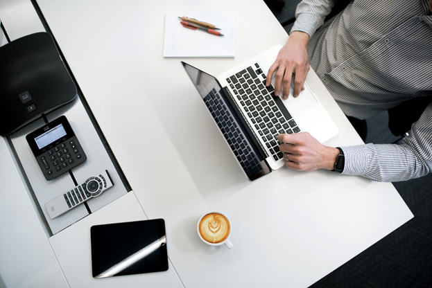  a person using a laptop and drinking coffee